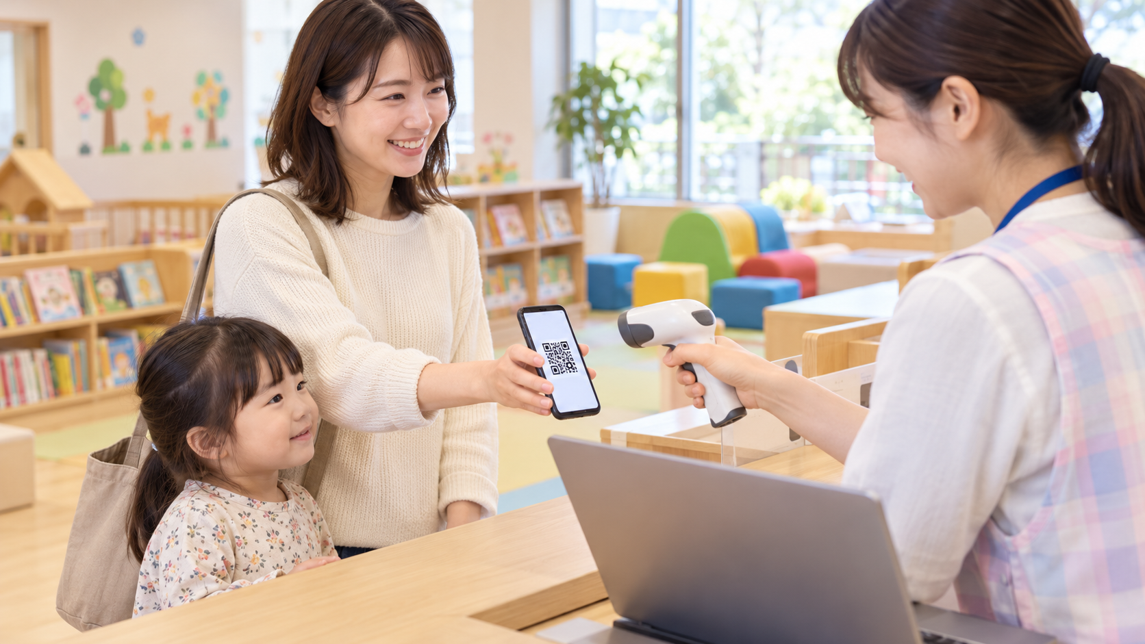 日本の自治体が運営する明るい子育て支援施設の受付で、保護者がスマートフォンに保存したQRコードを提示し、スタッフがバーコードリーダーで読み取っている。カウンターにはノートPC。保護者の隣に未就学の子ども、背景に絵本棚と柔らかい遊具。実在施設名、自治体名、企業ロゴ、氏名、読める文字なし、横長16対9の自然な写真品質のイメージ。